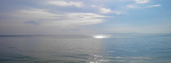 The ocean is calm and the sky is cloudy