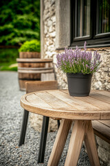 Fototapeta premium A wooden table with a pot of lavender flower outside a stone cottage during a sunny day in a tranquil garden setting