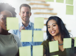 Idea, brainstorming and woman with business people in meeting for planning, discussion and task schedule. Office, startup and workers with sticky notes on glass for teamwork, research and project