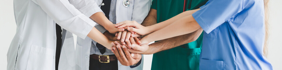 Obraz premium Teamwork group doctor surgeon nurse putting their hand together on white background medical health care solidarity concept