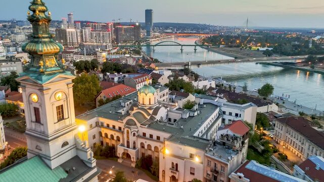 Flying over Cathedral of Saint Michael, Sava river, bridges and old town in Belgrade - capital of Serbia. Sunset view of Belgrade with city lights