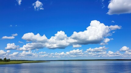 Obraz premium Bright blue sky with fluffy white clouds stretching across the horizon over a calm landscape
