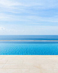 Fototapeta premium Tranquil infinity pool overlooking the vast ocean on a sunny day, with clear blue skies enhancing the serene atmosphere