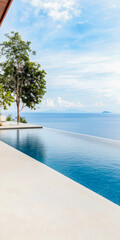 Fototapeta premium Tranquil infinity pool overlooking a serene ocean and distant island under a clear blue sky in a tropical paradise