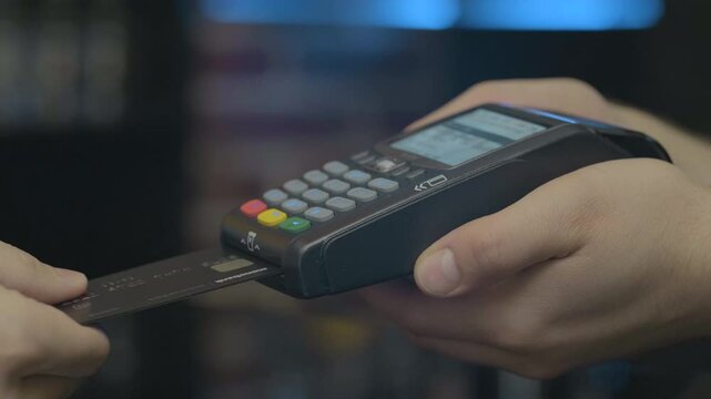 Credit card machine for money transaction. Man hand with credit card swipe through pos terminal and enter pin code. Banking services of electronic money. Financial success and safety.