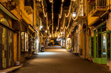 Fototapeta premium beautiful Christmas holiday street with decorated buildings and bright garlands in a New Year city