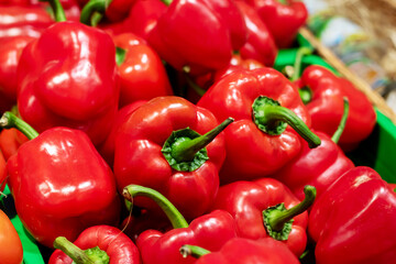 A green basket that is filled with vibrant red peppers is sitting on a table