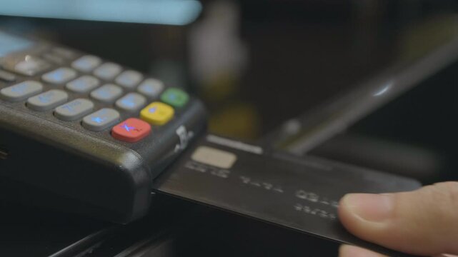 Credit card machine for money transaction. Man hand with credit card swipe through pos terminal and enter pin code. Banking services of electronic money. Financial success and safety.