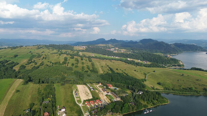 Fototapeta premium Lake Czorsztyn aerial view with green fields and mountains