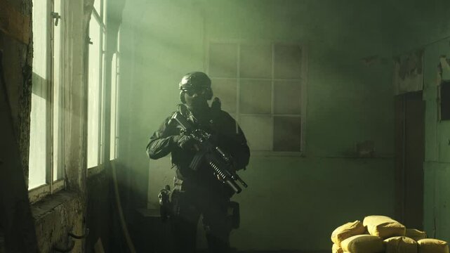 Special forces operator in black military gear and an m4 assault rifle in a room full of smoke