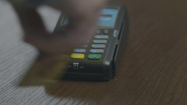 Closeup shot of customer pay over the wireless tradings card-reader. Adult human hands of businessman use bankcard: leans, entering password to withdraw funds then hold and sliding. Noncash payments.