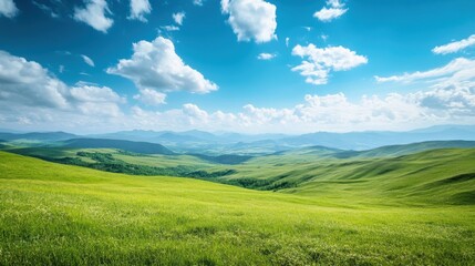 Obraz premium Breathtaking Panoramic View of Rolling Green Hills Under a Vibrant Blue Sky with Fluffy White Clouds