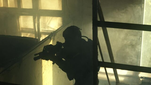 SWAT forces operator in black gear walking up a rusty old staircase in an abandoned warehouse