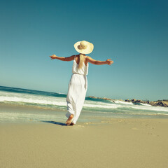Woman, hat and walking on beach for freedom, sun protection and back for water adventure. Female person, outdoor and playful girl on shore of tropical island, tourist and holiday trip to Mauritius