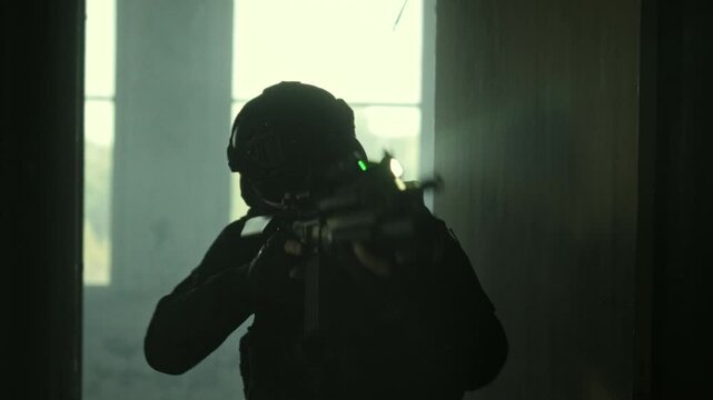 SWAT operator in all black gear and an assault rifle breaching a door in an abandoned warehouse