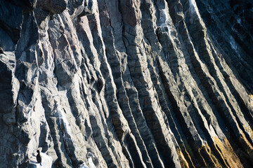 Natural structures and shapes from Iceland. Beautiful natural scenery for the background. Rock wall texture. Granite, basalt, gneiss and other intrusive or effusive rocks.