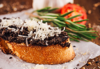 Delicious bruschetta with black truffle cream and parmesan cheese on wooden table
