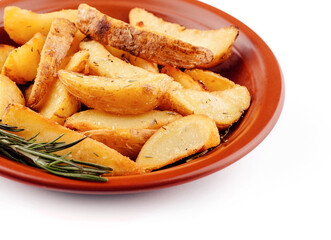 Delicious baked potato wedges with rosemary lying on a plate