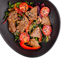 Warm salad with sliced beef, cherry tomatoes and sesame seeds on black plate