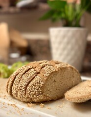 A loaf of sesame seed bread, sliced on a cutting board with a plant in the background, showcasing a wholesome and artisanal feel