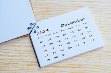 Top view of December 2024 calendar on wooden background. Calendar month of year 2024 concept
