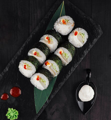 Sushi rolls set served on black slate plate