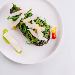 Gourmet salad inside baked eggplant dish on white background