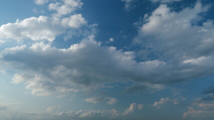 Obraz premium Tropical summer sunlight. Blue sky with cumulus and stratocumulus clouds. Fluffy layered clouds sky atmosphere. Timelapse.