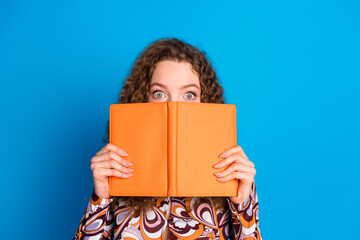 Photo portrait of pretty young girl read book cover hide face wear trendy colorful outfit isolated on blue color background