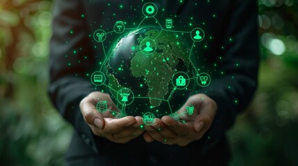 A person holds a glowing digital globe surrounded by technology icons in a lush green environment during daylight