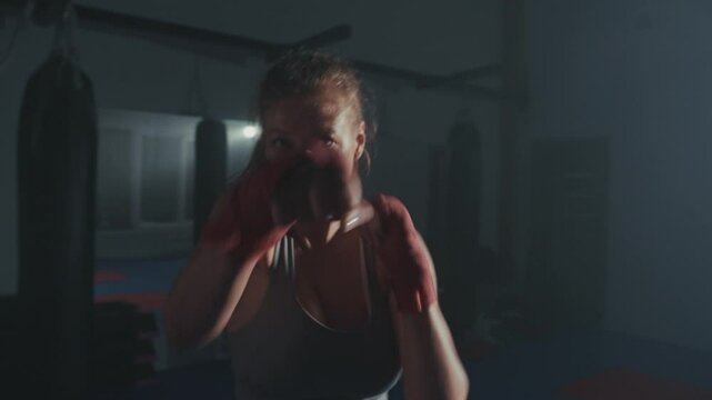 Intense training session featuring a boxer practicing techniques in a dimly lit gym