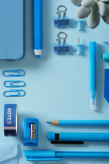 Blue stationery frame of felt pens, pencils, eraser, paper clips, pins, sharpener. Light blue background, space for your text.