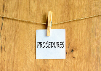 Procedures symbol. Concept word Procedures on beautiful white paper on clothespin. Beautiful wooden background. Business procedures concept. Copy space.