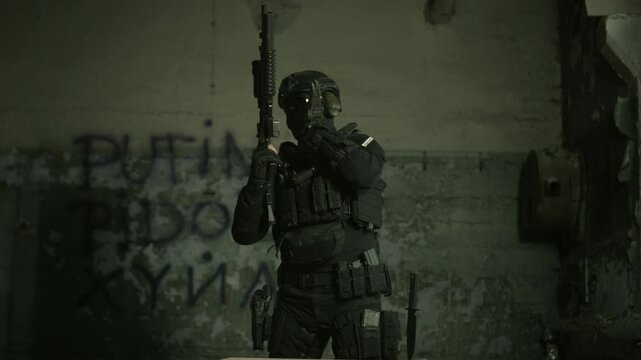 Special forces operator in black military gear inserting a magazine in his m4 assault rifle