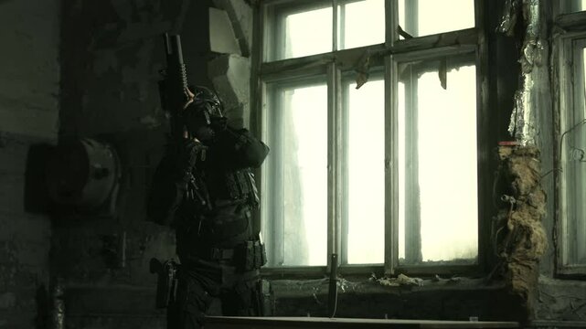 Special forces operator in black military gear inserting a magazine in his m4 assault rifle
