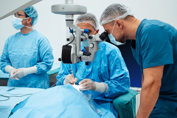 Skilled surgeon and his medical team performs precise eye surgery on an elderly patient, restoring...
