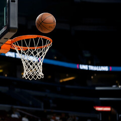 Fototapeta premium Basketball hoop and basketball about to go into the hoop
