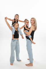 Happy fashionable modern family concept. Young mom with her daughters, posing in studio.  Enjoy time together. Copy space.	