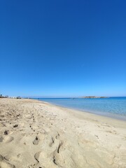 Fototapeta premium Golden sand beach with clear blue sky