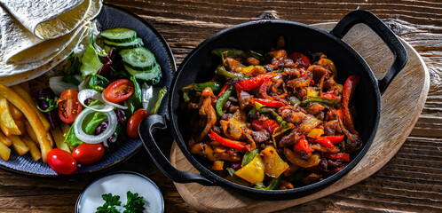 Fajita with peppers and onions served on a hot iron skillet