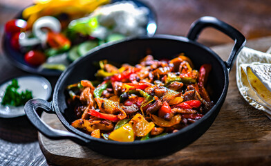 Fajita with peppers and onions served on a hot iron skillet