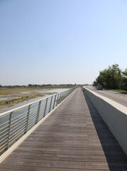 Naklejka premium cycle path made of wood and steel railings that runs along the Venetian lagoon at Treporti near Jesolo and the island of Venice