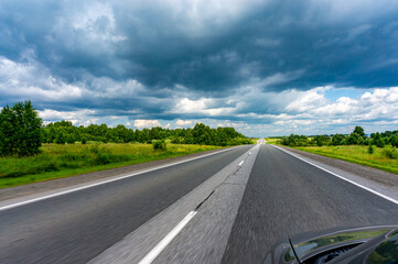 Asphalt road and cloudy sky in the countryside, motion blur.