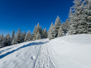 Serene winter landscape with snow and frost covered mountains on a bright sunny day