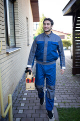 Front view of a handyman with a tool case. He goes to the work