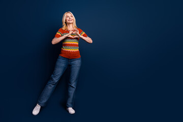 Photo of pretty cheerful woman wear stylish clothes showing heart shape empty space isolated on dark blue color background