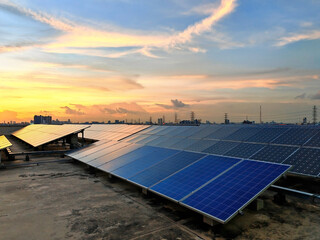 Solar panels on rooftop of office building against sunset sky
