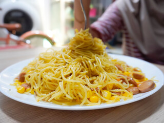 Homemade recipe classic aglio e olio spaghetti with smoked beef and grated corn, close-up in a white plate on the table