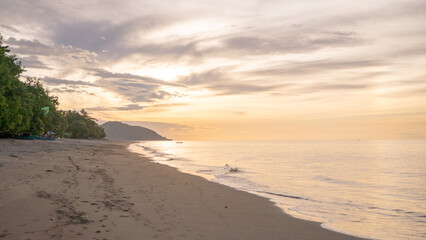 Peaceful Beach Sunset. Tranquil beach scene with soft golden sunlight and calm water at sunset.