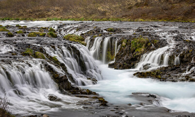 Obraz premium wide cascade over the lava stones, Brúarfoss, Iceland